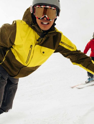 Man Snowboarding with Apple Watch with Girl Skiing on Mountain